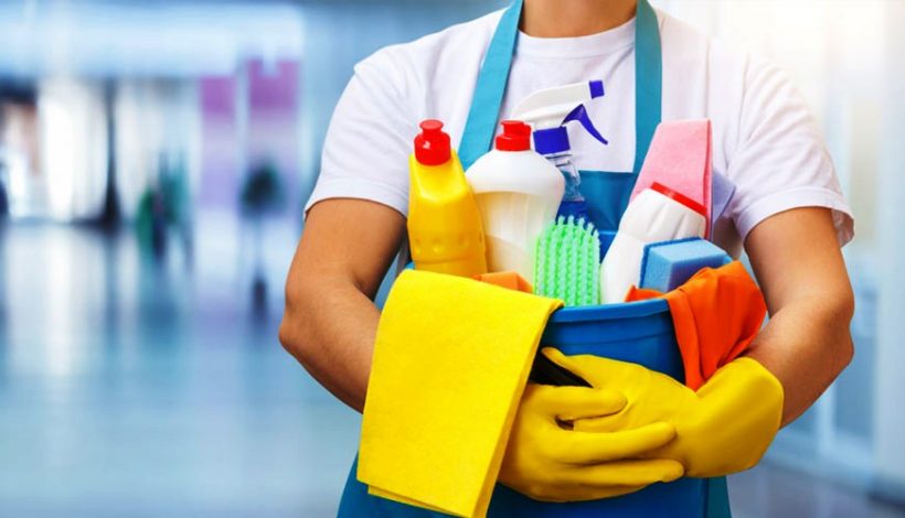 Professional cleaner holding a bucket of commercial cleaning supplies